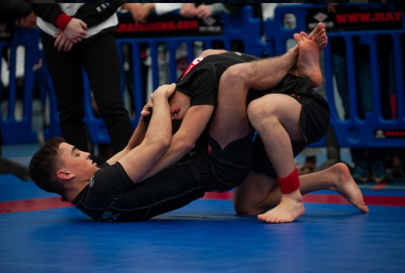 Two people in a BJJ match, the fighters are in closed guard